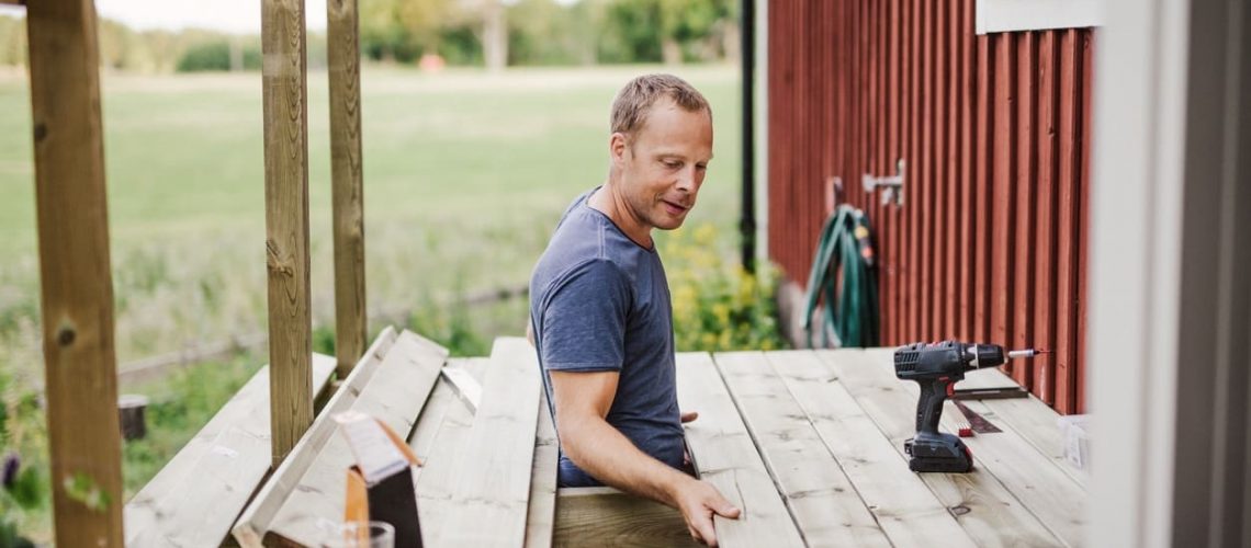 Man building a patio outside his country side house