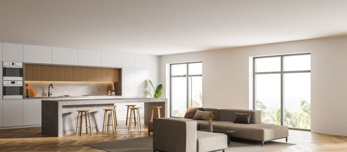 Corner of stylish living room with white walls, wooden floor, white sofas and kitchen in the background. 3d rendering